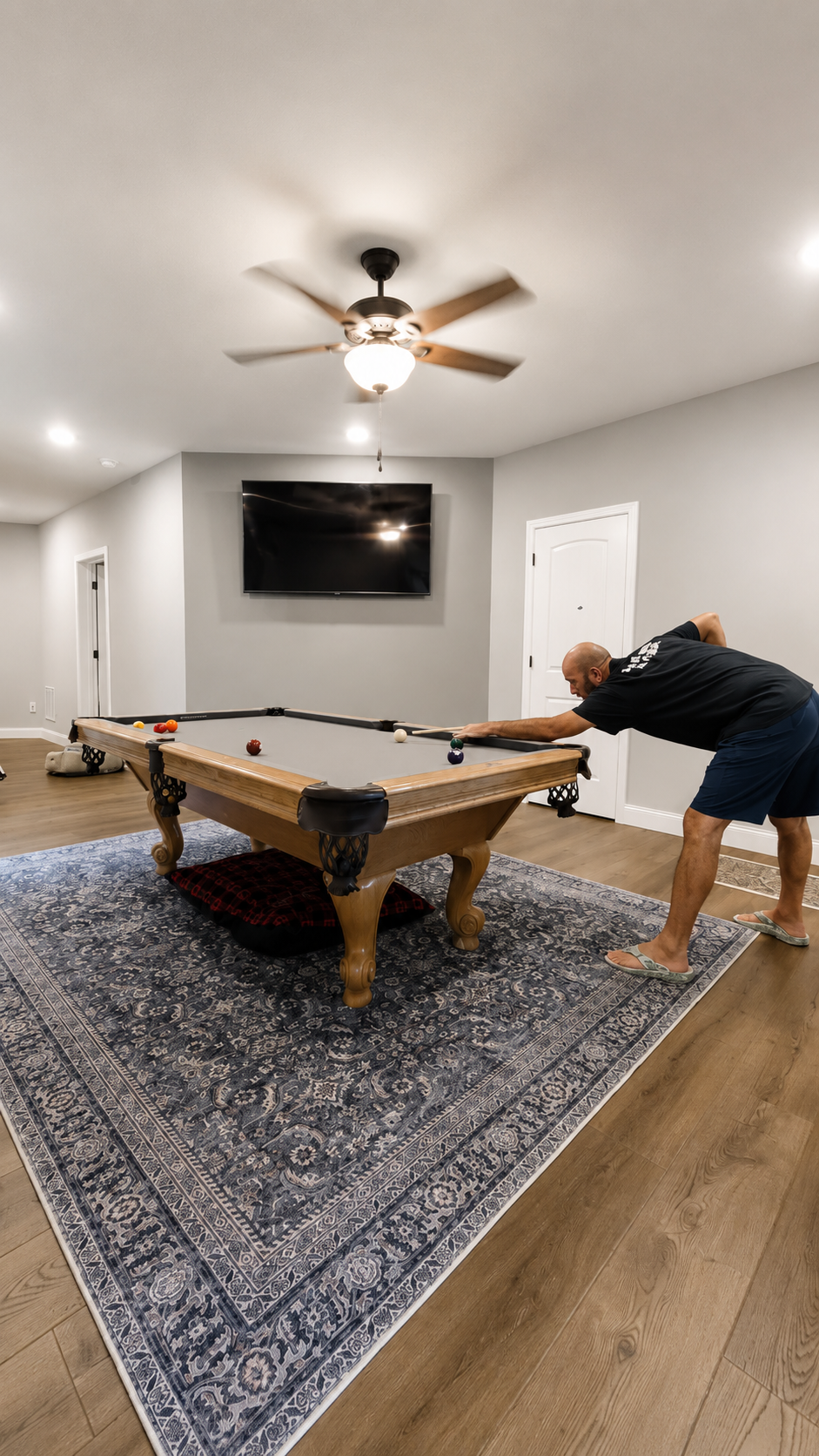 Finished game room with pool table, wall-mounted television, and wood-look flooring