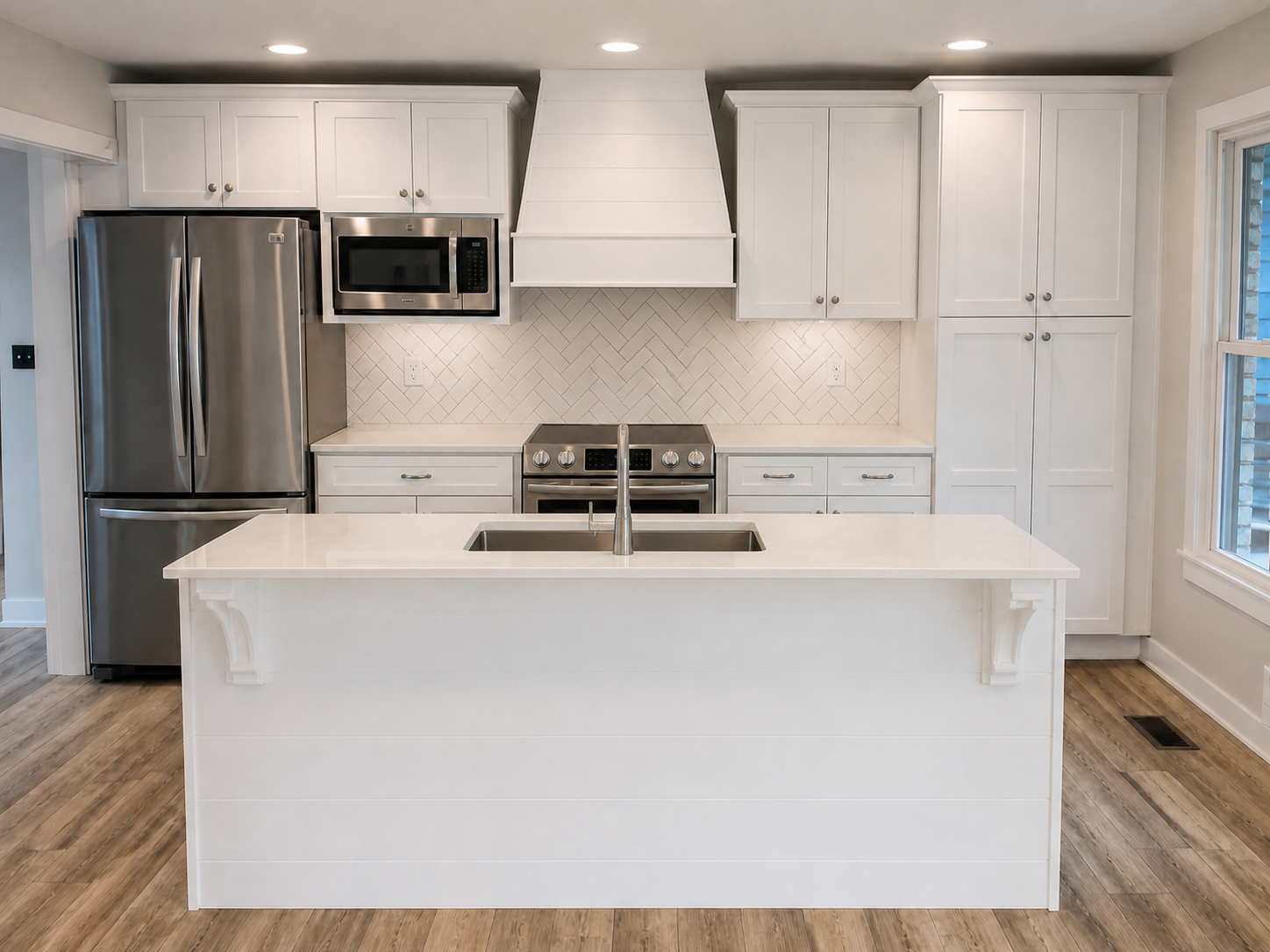 Finished white kitchen cabinetry with stainless appliances and herringbone backsplash